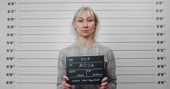 Portrait of Blond Hair Woman Holding Sign for Photo in Police Department