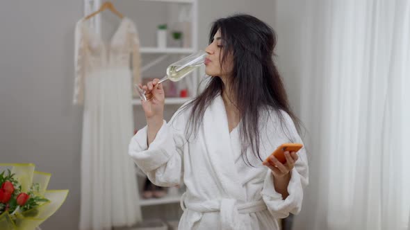 Confident Modern Middle Eastern Woman Drinking Champagne From Glass Messaging Online on Smartphone