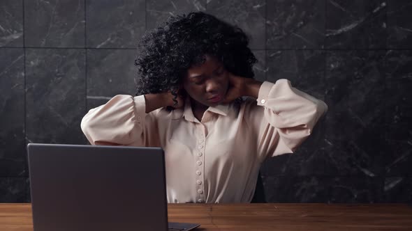 Bored Afroamerican Secretary with Curly Hair Stretches Back