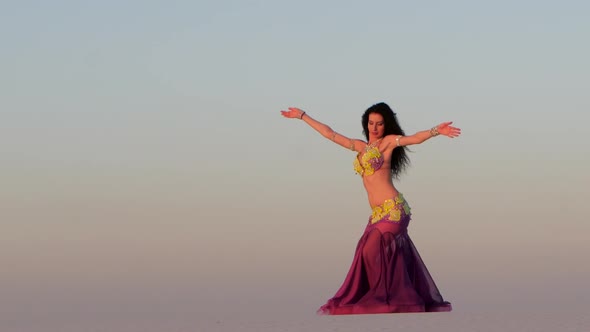 Professional Dancer in a Shiny Suit Makes Sexual Movements Against the Blue Sky