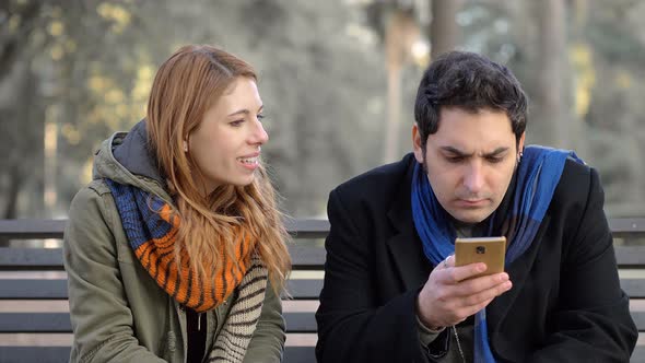 woman talking her absent-minded boyfriend using smartphone,starting fight