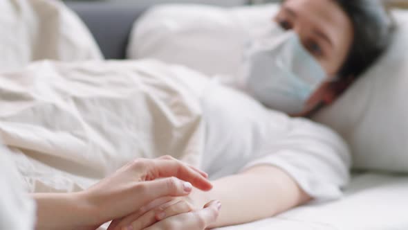 Woman Supporting Sick Female Patient in Protective Face Mask