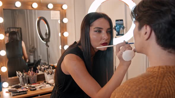 Makeup Studio - Makeup Artist Applying Lipstick on the Lips of Male Model Using a Brush