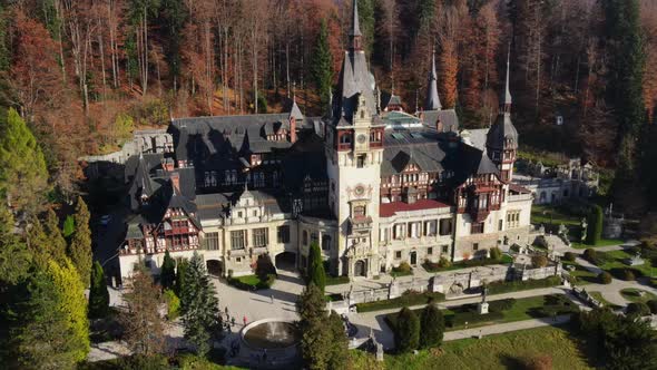 Aerial drone view of The Peles Castle in Romania. Castle with gardens in Carpathians, forest around 