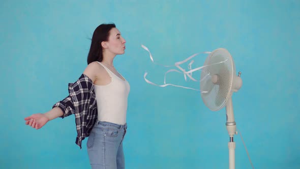 Young Woman with Electric Fan Enjoying Cool Wind