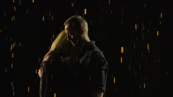 Silhouettes of Man and Woman Close Up Stand in the Rain and Enjoy the Moment. Raindrops Glisten in