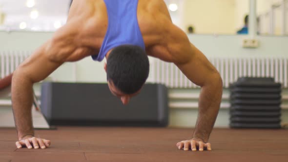 Close Up to Muscular Man Doing Push Ups in Handstand at Gym