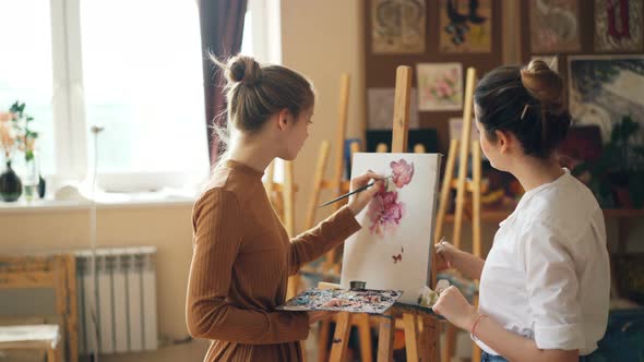Beautiful Blond Girl Is Depicting Flowers at Art Class Under Guidance of Experienced Teacher