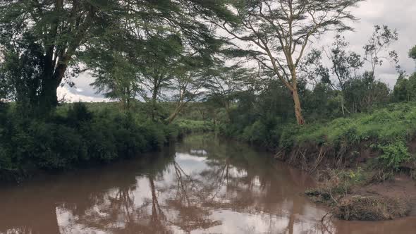 Forwards aerial drone view of river in African landscape in Laikipia, Kenya