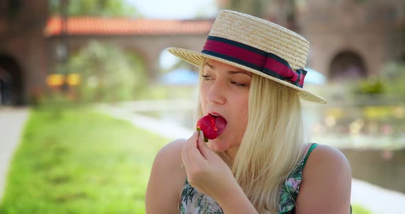 Attractive Woman Eating Strawberry. People and Food Concept Slow Motion Footage