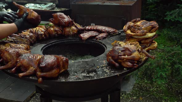 Chef flips the chicken grill. Grilled chicken during a street food festival. Grilled Rotisserie