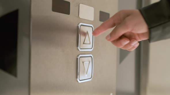 Woman Presses the Elevator Button to Go Upstairs