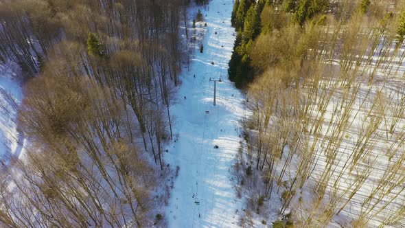 Old Ski Station on a Snowy Mountain Slope with a Lot of People on Skis and Snowboards