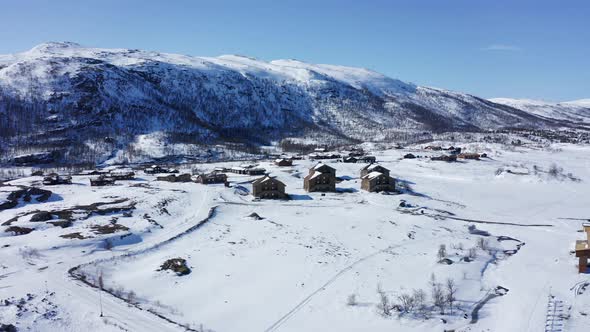 Maurset Hardangervidda Norway - Aerial showing vacation homes in between snowy mountains close to rv