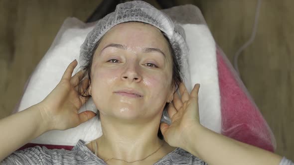 Portrait of Woman in Beauty Clinic Salon. Girl with Moisturizing Mask on Face