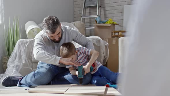 Father Helping Son with Electric Screwdriver alt