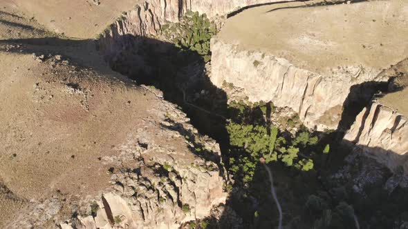 Aerial Deep Long Rift Canyon with Cleft Steep Rock Walls and High Cliff Gorge