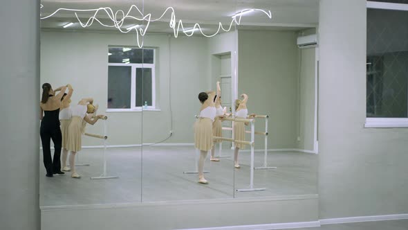 Wide Shot Reflection in Mirror Group of Ballerinas in Covid19 Face Masks Rehearsing Fourth Hand