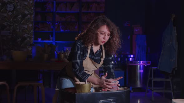 Pottery Crafting Young Woman Artist Adding Finishing Touches to a New Clay Pot That She Made in the