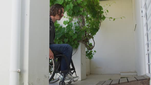 Caucasian disabled man in wheelchair entering door of his house