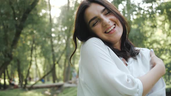 Pretty Positive Brunette Cute Smiles for a Beautiful Photo. Happy Young Woman Poses for a Beautiful