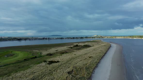 Aerial view of drone tracking left, over  Irish beach at golden hour.