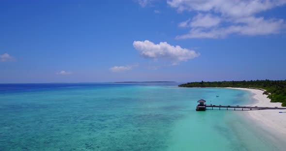 Daytime birds eye clean view of a white sandy paradise beach and blue ocean background in 4K