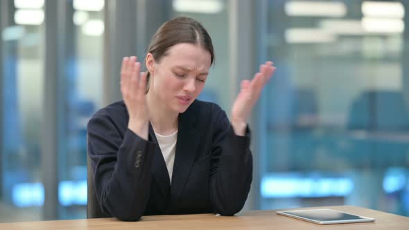 Upset Young Businesswoman Feeling Worried While Sitting in Office