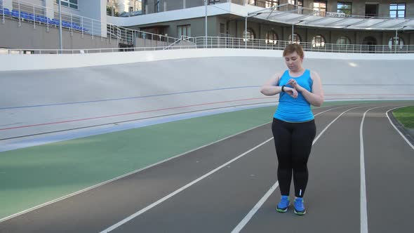 Woman Jogger Using Fitness Bracelet During Running