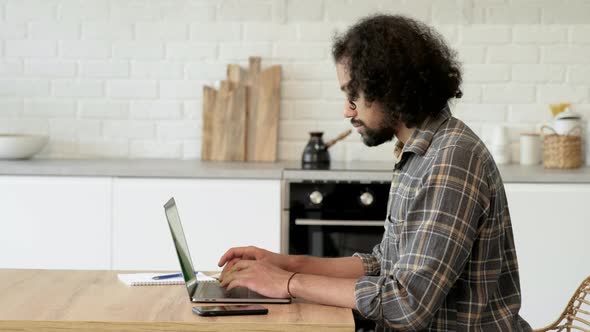 Handsome Indian Specialist Working on Laptop Computer at Home Living Room. Freelance Man