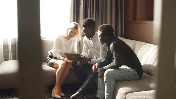 Multiracial Business Team Using Laptop While Sitting on the Couch