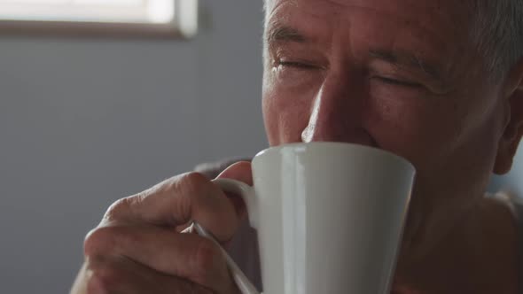 Senior man drinking coffee at home