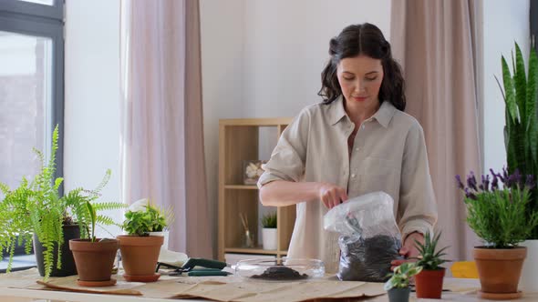 Happy Woman Planting Pot Flowers at Home