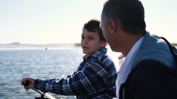 Closeup Father and Son are Fishing on a Sunny Day While Sitting in a Boat Spending Good Moments