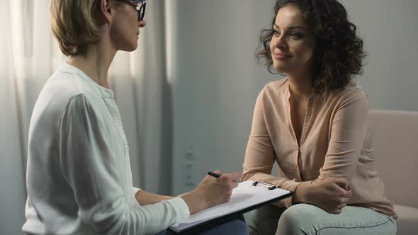 Curly Haired Woman Having Conversation With Professional Psychologist at Clinic