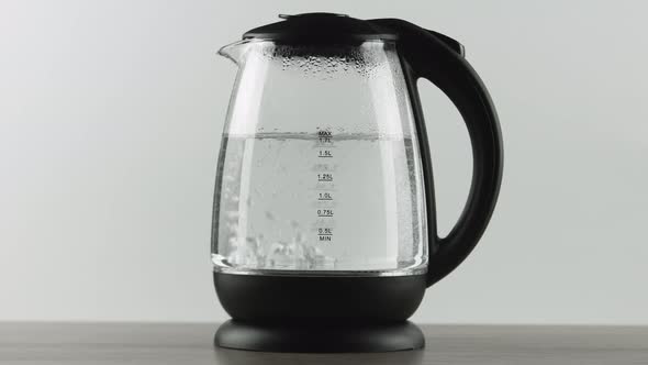 In a Electric Kettle with Transparent Glass Walls, Water Boils. White Background