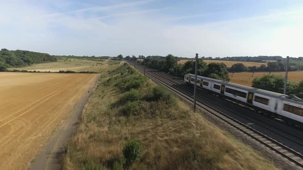 Fast Commuter Train Speeding Through the Countryside During Summer