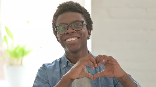 Young African Man Showing Heart Shape By Hands