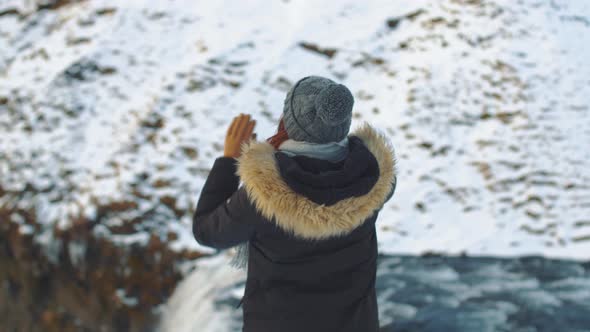 Woman Traveler on the Top of Famous Waterfall Skogafoss in Iceland