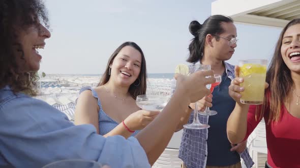 Friends Cheers Dancing and Having Fun Drink Color Cocktails in a Rooftop Bar