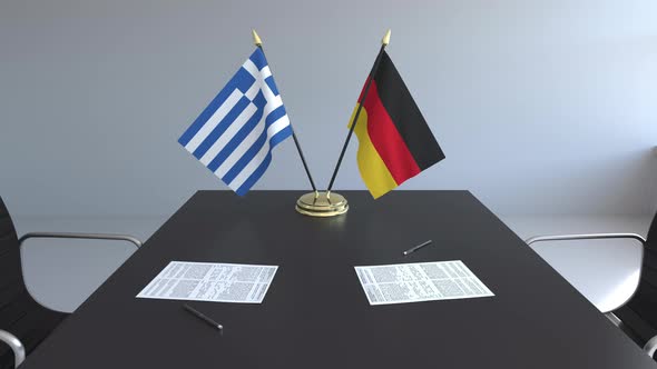 Flags of Greece and Germany and Papers on the Table