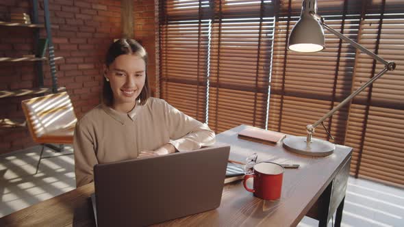 Positive Business Lady Web Conferencing on Laptop in Office