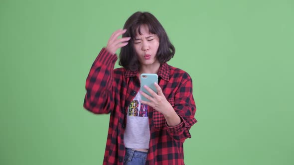 Stressed Asian Hipster Woman Using Phone and Getting Bad News