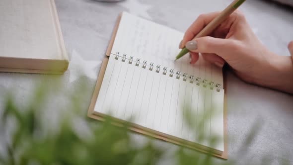 Young woman makes notes in her diary.