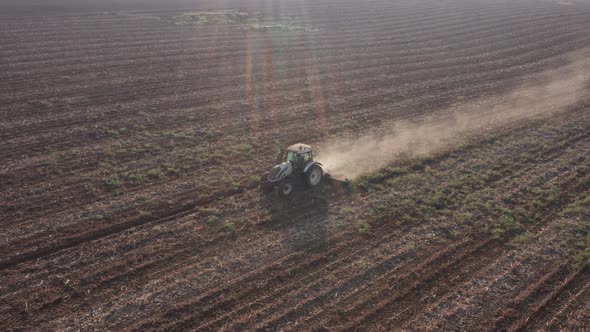 Red Tractor plowing a large field, Early morning follow footage.