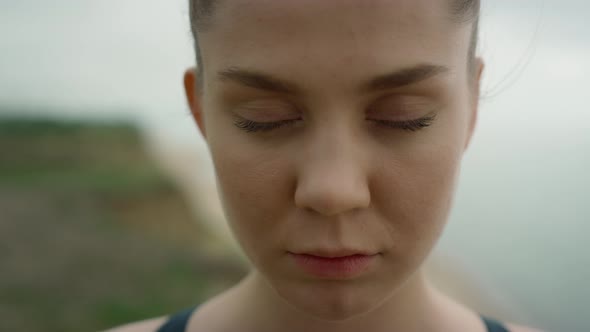 Calm Woman Opening Eyes Standing on Beach Close Up