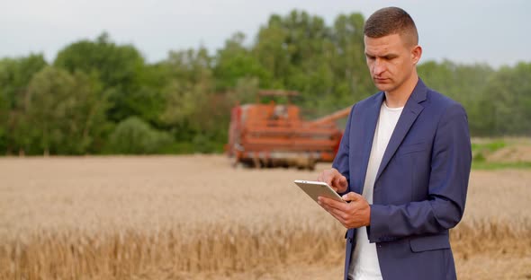 Agriculture - Farmer Using Digital Tablet During Harvesting