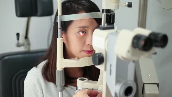Patient with head in medical device for examining for eye sight 