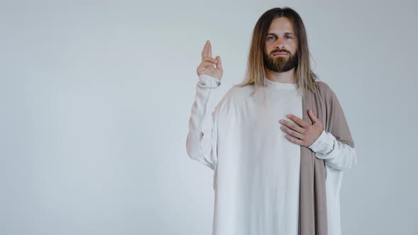 Jesus with a Raised Hand Looks Into the Camera on a White Background alt