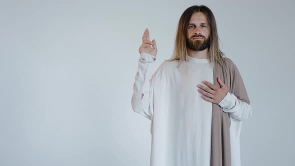 Jesus with a Raised Hand Looks Into the Camera on a White Background
